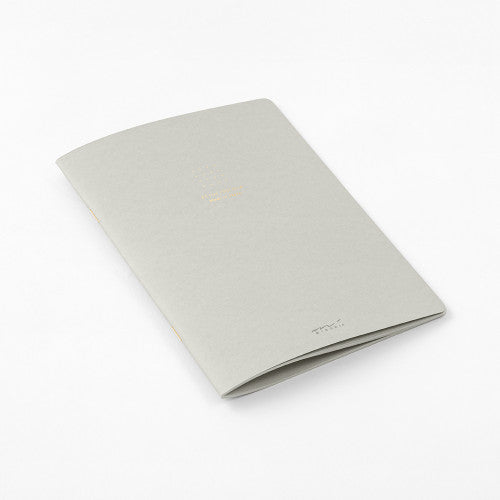Single Midori A5 grey notebook with colour dot grid pages on a plain background.