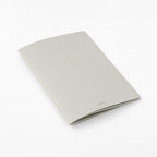 Single Midori A5 grey notebook with colour dot grid pages on a plain background.