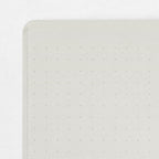Single Midori A5 grey notebook with colour dot grid pages on a plain background.