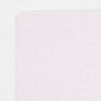 Single Midori A5 purple notebook with colour dot grid pages on a plain background.