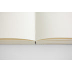 Open 15th anniversary limited edition MD Notebook with embossed Holly Wales design, on a light grey background.