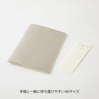 Single Midori A6 grey commonplace notebook on a plain background.