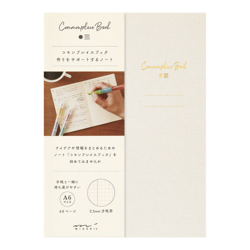 Single Midori A6 beige commonplace notebook on a plain background.