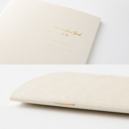 Single Midori A6 beige commonplace notebook on a plain background displayed flat.