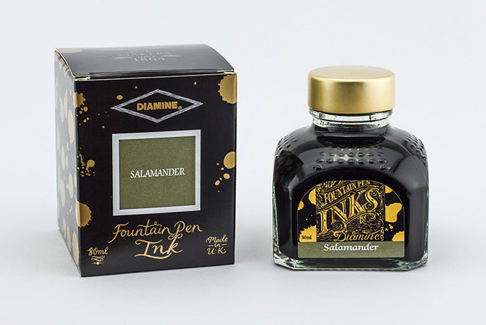 A glass bottle of 80ml Diamine Salamander fountain pen ink next to its packaging box, in front of a white background.