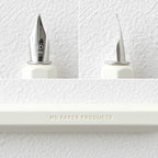 MD Dip Pen close up at nib and embossing on the side "MD PAPER PRODUCTS", against a white background.