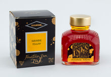 Load image into Gallery viewer, A glass bottle of 80ml Diamine Sunshine Yellow fountain pen ink next to its packaging box, in front of a white background.
