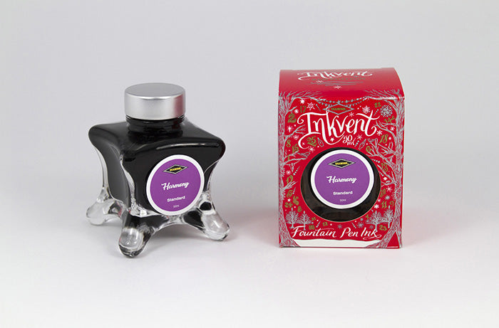 A glass bottle of 50ml Diamine Red Edition Inkvent Harmony fountain pen ink next to packaging box, in front of a white background.