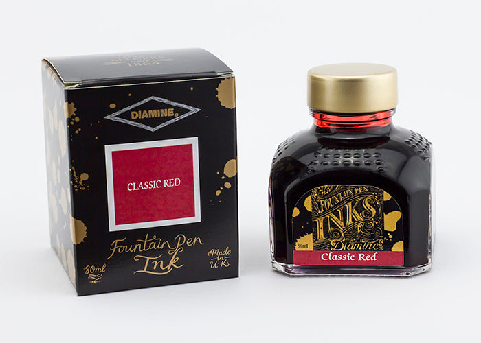 A glass bottle of 80ml Diamine Classic Red fountain pen ink next to its packaging box, in front of a white background.