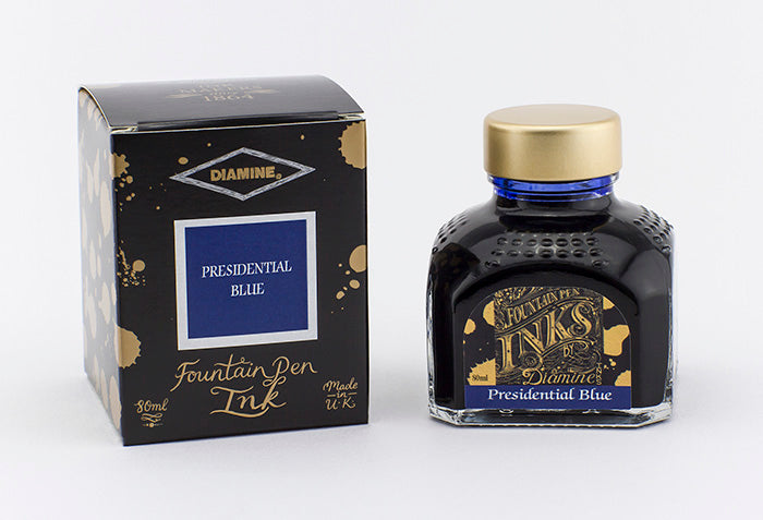 A glass bottle of 80ml Diamine Presidential Blue fountain pen ink next to its packaging box, in front of a white background.