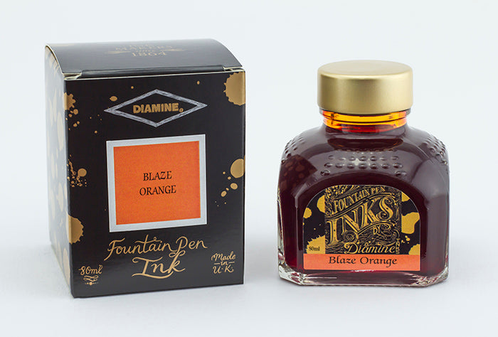 A glass bottle of 80ml Diamine Blaze Orange fountain pen ink next to its packaging box, in front of a white background.