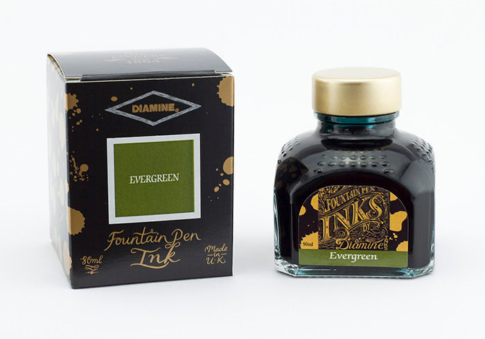 A glass bottle of 80ml Diamine Evergreen fountain pen ink next to its packaging box, in front of a white background.