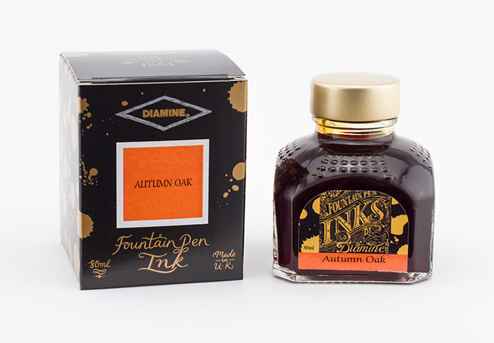 A glass bottle of 80ml Diamine Autumn Oak fountain pen ink next to its packaging box, in front of a white background.