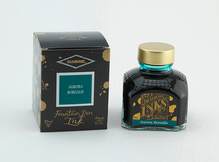 A glass bottle of 80ml Diamine Aurora Borealis fountain pen ink next to its packaging box, in front of a white background.