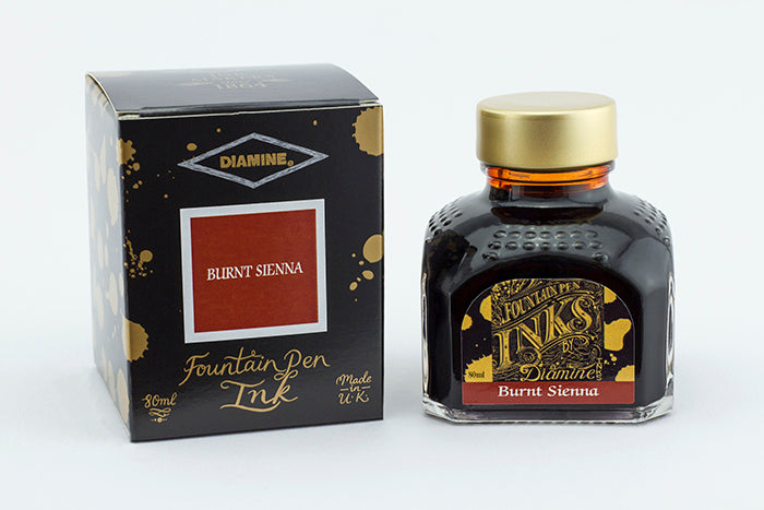 A glass bottle of 80ml Diamine Burnt Sienna fountain pen ink next to its packaging box, in front of a white background.