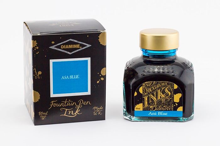 A glass bottle of 80ml Diamine Asa Blue fountain pen ink next to its packaging box, in front of a white background.