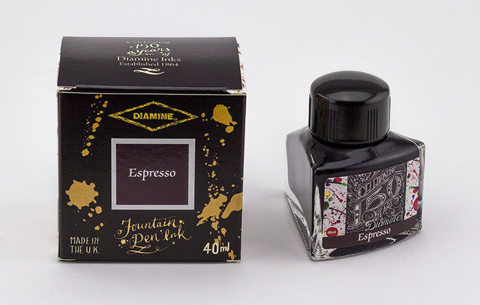 A glass bottle of 40ml Diamine 150th Anniversary Espresso fountain pen ink next to packaging box, in front of a white background.