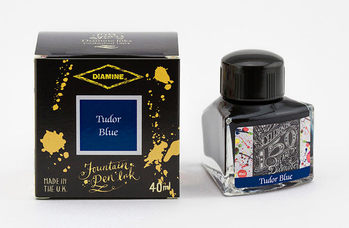 A glass bottle of 40ml Diamine 150th Anniversary Tudor Blue fountain pen ink next to packaging box, in front of a white background.