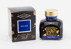 A glass bottle of 80ml Diamine Royal Blue fountain pen ink next to its packaging box, in front of a white background.