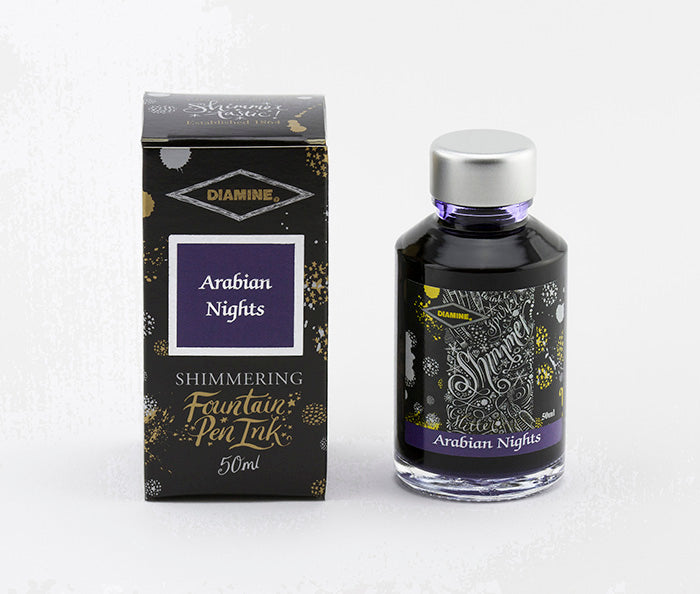 A glass bottle of 50ml Diamine Arabian Nights shimmering fountain pen ink next to its packaging box, in front of a white background.