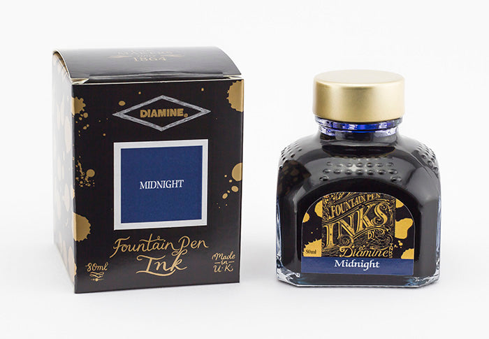A glass bottle of 80ml Diamine Midnight fountain pen ink next to its packaging box, in front of a white background.