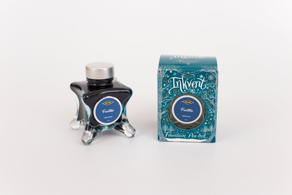 Glass bottle of 50ml Diamine Teal Edition Inkvent Frostbite shimmer fountain pen ink next to Teal coloured and Christmas-themed packaging box, in front of a white background.