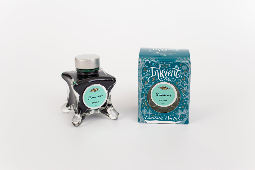 Glass bottle of 50ml Diamine Teal Edition Inkvent Bittersweet fountain pen ink next to Teal coloured and Christmas-themed packaging box, in front of a white background.