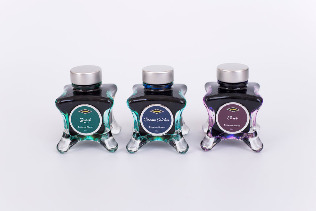 Group of three glass bottles of 50ml Diamine Teal Edition Inkvent extreme sheen fountain pen ink, Laurel, Dream Catcher & Chaos. Sitting in front of a white background.