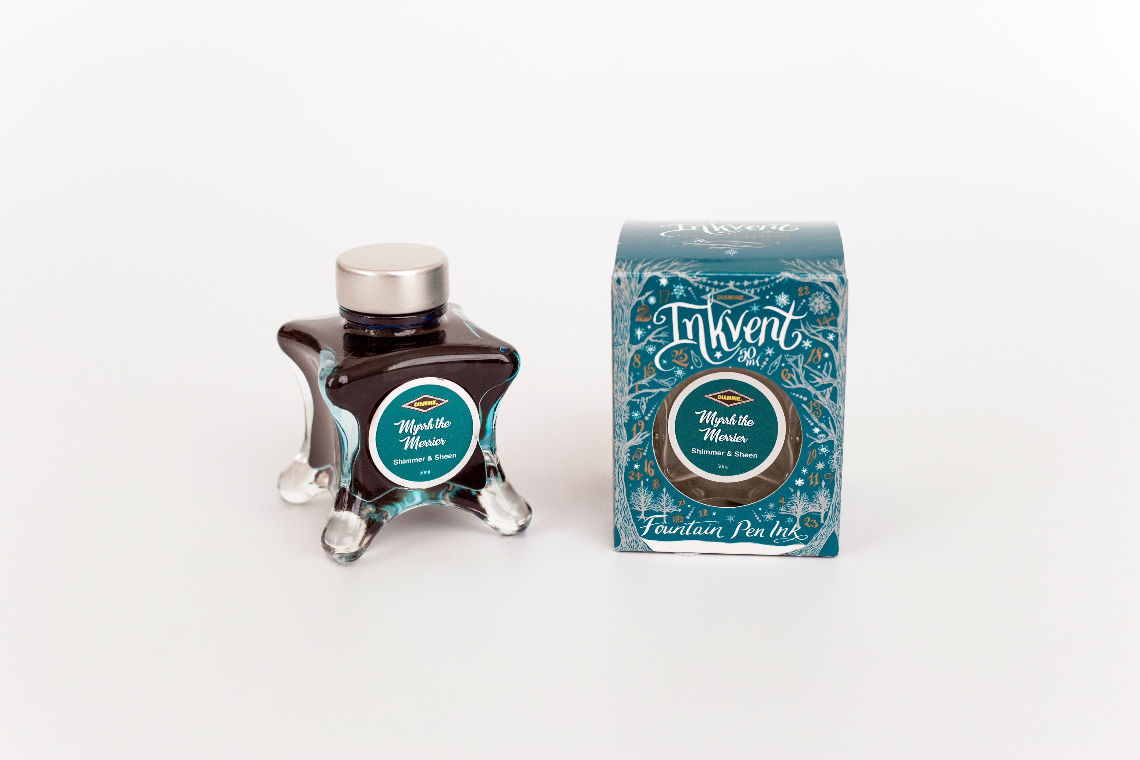 Glass bottle of 50ml Diamine Teal Edition Inkvent Myrrh the Merrier fountain pen ink next to Teal coloured and Christmas-themed packaging box, in front of a white background.