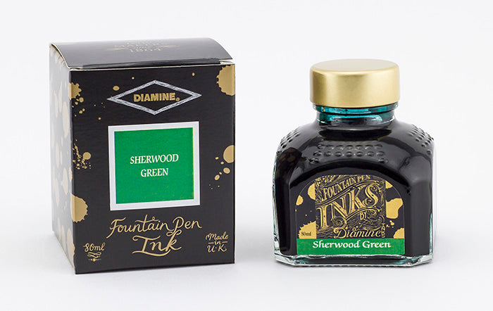 A glass bottle of 80ml Diamine Sherwood Green fountain pen ink next to its packaging box, in front of a white background.