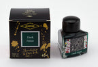 A glass bottle of 40ml Diamine 150th Anniversary Dark Forest fountain pen ink next to packaging box, in front of a white background.