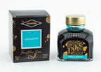 A glass bottle of 80ml Diamine Aqua Lagoon fountain pen ink next to its packaging box, in front of a white background.