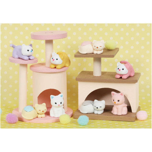 A group of pastel‑coloured Iwako cat erasers arranged on a miniature replica cat tree, each perched on different platforms like playful kittens.