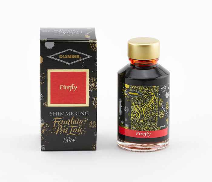 A glass bottle of 50ml Diamine Firefly shimmering fountain pen ink next to its packaging box, in front of a white background.