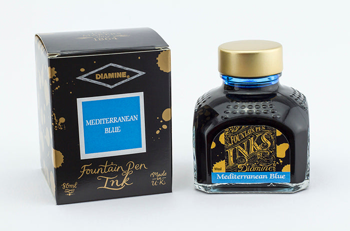 A glass bottle of 80ml Diamine Mediterranean Blue fountain pen ink next to its packaging box, in front of a white background.