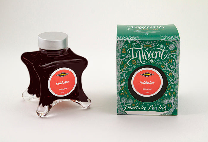 A glass bottle of 50ml Diamine Green Edition Inkvent Celebration shimmer fountain pen ink next to packaging box, in front of a white background.