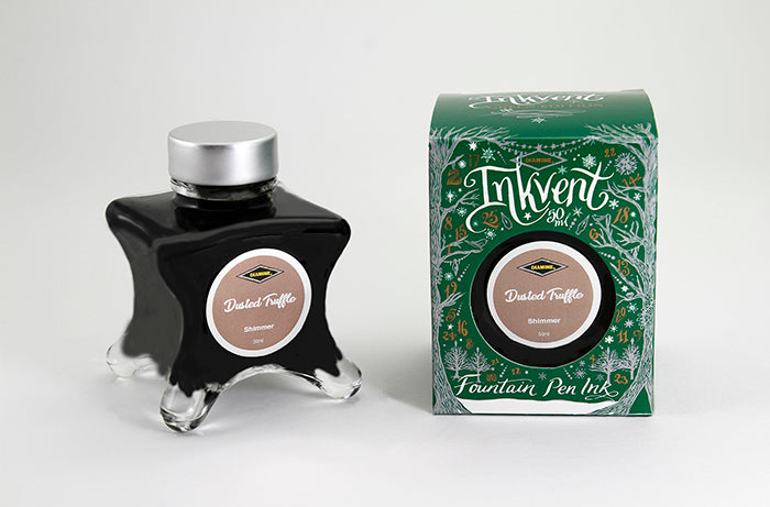 A glass bottle of 50ml Diamine Green Edition Inkvent Dusted Truffle shimmer fountain pen ink next to packaging box, in front of a white background.