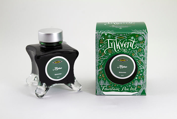 A glass bottle of 50ml Diamine Green Edition Inkvent Alpine shimmer fountain pen ink next to packaging box, in front of a white background.