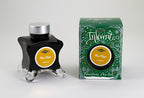 A glass bottle of 50ml Diamine Green Edition Inkvent Three Kings fountain pen ink next to packaging box, in front of a white background.