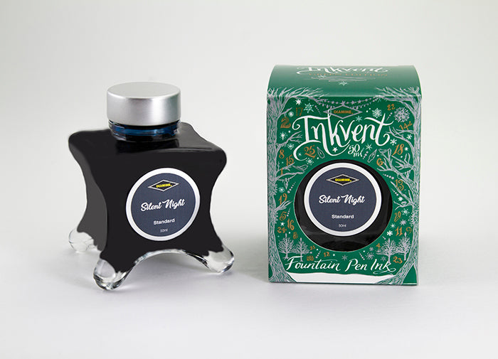 A glass bottle of 50ml Diamine Green Edition Inkvent Silent Night fountain pen ink next to packaging box, in front of a white background.
