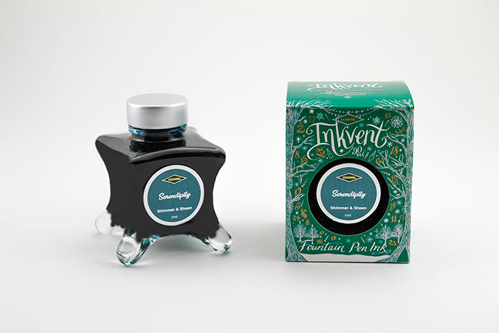 A glass bottle of 50ml Diamine Green Edition Inkvent Serendipity shimmer fountain pen ink next to packaging box, in front of a white background.