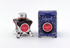 A glass bottle of 50ml Diamine Blue Edition Inkvent Candy Cane fountain pen ink next to packaging box, in front of a white background.