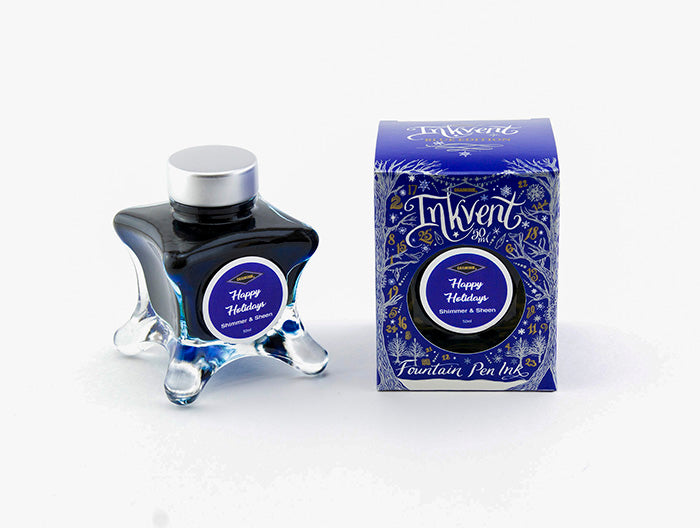 A glass bottle of 50ml Diamine Blue Edition Inkvent Happy Holidays shimmer fountain pen ink next to packaging box, in front of a white background.