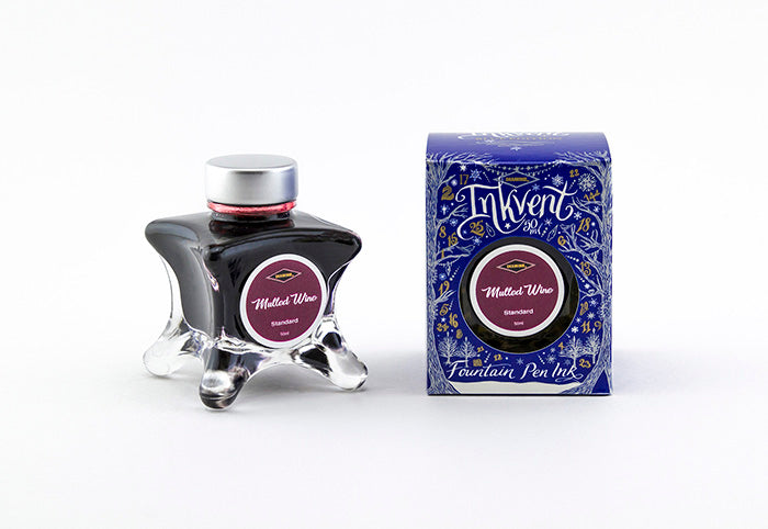 A glass bottle of 50ml Diamine Blue Edition Inkvent Mulled Wine fountain pen ink next to packaging box, in front of a white background.